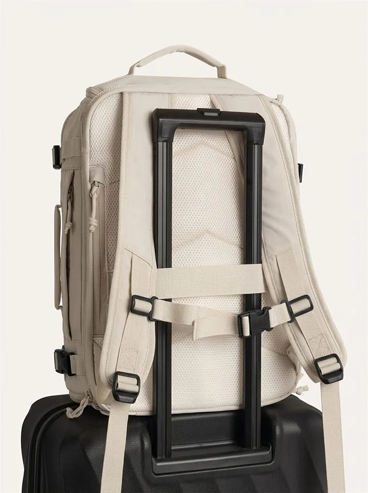 Backpack sliding onto a suitcase handle with the trolley strap